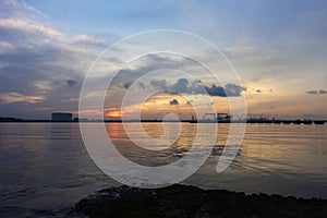 A beautiful sunrise with cloudy sky on the beach.