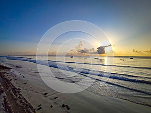 Beautiful sunrise on Diani beach on the Indian Ocean. It is a sunny morning in Kenya, Africa. There are small wooden