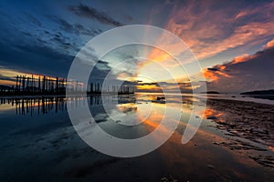 Beautiful sunrise landscape at blue and orange sky above it with light reflection on sea