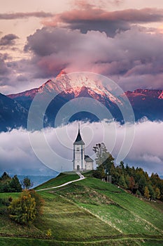 Beautiful sunrise landscape of church Jamnik in Slovenia with cloudy sky