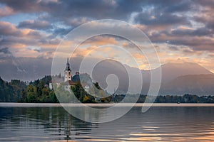 Beautiful sunrise landscape of famous lake Bled in Slovenia with small church on green island