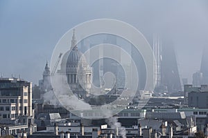 Beautiful sunrise landscape image of fog above London city landmarks with besutiful soft light on skyscrapers