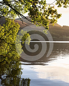 Beautiful sunrise landscape image looking across Loweswater in the Lake District towards Low Fell and Grasmere with vibrant