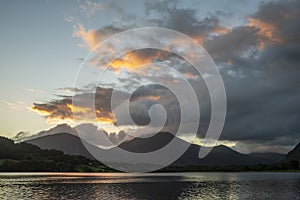 Beautiful sunrise landscape image looking across Loweswater in the Lake District towards Low Fell and Grasmere with vibrant