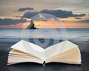 Beautiful sunrise landsdcape of idyllic Broadhaven Bay beach on Pembrokeshire Coast in Wales coming out of pages on book in