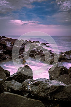 Beautiful sunrise over the beach in long exposure. Moving elements sunrise and wave photography from the rocky beach in india.