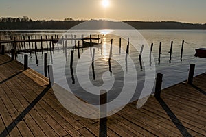 Beautiful sunrise over a dock by a calm, serene Lake Bagsvaerd