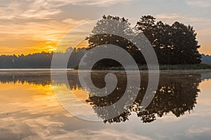 Beautiful sunrise over misty lake.