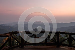 Beautiful sunrise over mountain range view from wooden terrace