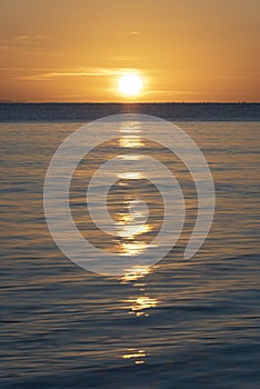 Beautiful sunrise over Pentewan Sands in Cornwall with pastel sky and long exposure ocean