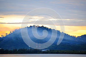 Beautiful sunrise over sea with fog on mountain