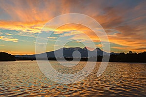 Beautiful sunrise over volcanoes Kluchevskaya group with reflection in the river Kamchatka.