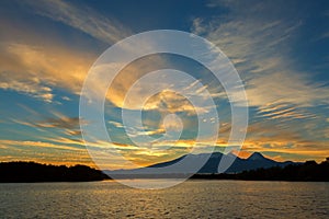 Beautiful sunrise over volcanoes Kluchevskaya group with reflection in the river Kamchatka.