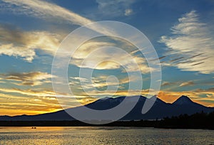 Beautiful sunrise over volcanoes Kluchevskaya group with reflection in the river Kamchatka.