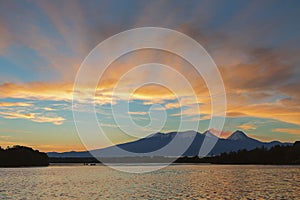 Beautiful sunrise over volcanoes Kluchevskaya group with reflection in the river Kamchatka.