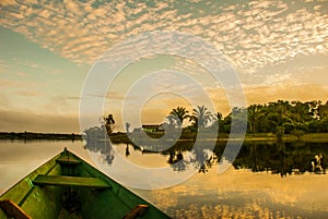 Beautiful sunrise on the river. View from the boat at Amazon river, with a dense forest on the shore and blue sky, Anazonas,