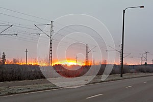 Beautiful sunrise at road and railroad at autumn in Finland