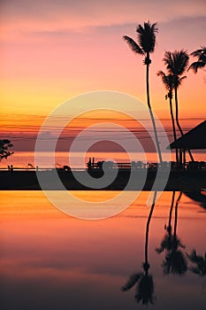 Beautiful Sunrise with silhouette coconut palm tree and swimming pool in beautiful luxury hotel resort