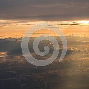 Beautiful sunrise view above the clouds with dramatic light from airplace window photo