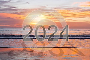 Beautiful sunset with 2024 and shadow on beach. Copy space for text. Happy new year 2024 concept