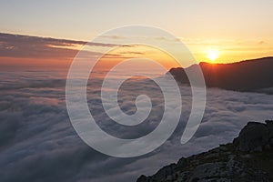 Beautiful sunset above the clouds in the mountains