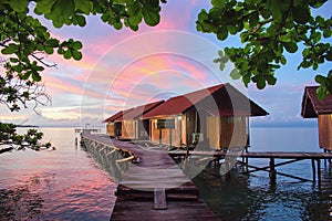 Beautiful sunset above typical water bungalows on the beach - Waigeo Island, Raja Ampat, West Papua, Indonesia