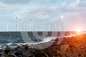 Sunset above windmills in the ocean