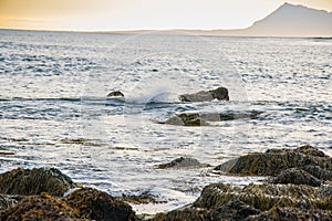 Beautiful Sunset in the Atlantic Ocean of Icealand with Waves Crashing the Rocks