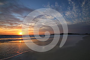 Beautiful sunset on the beach with a dramatic blue sky, Airforce Beach, Australia