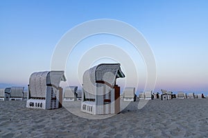 Beautiful sunset and beach evening with white beach baskets on sandy beach