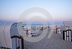 Beautiful sunset and beach evening with white beach baskets on sandy beach