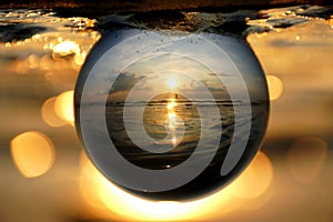 Beautiful sunset captured through a glass lens ball at Cape Henlopen State Park, Lewes, Delaware, U.S.A photo