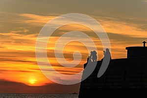 Beautiful sunset while catching the silhouette of two photographers, male and female