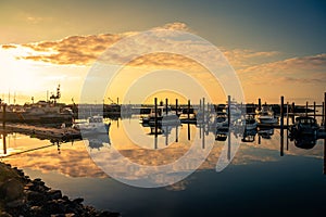 Beautiful sunset with clouds over marina with boats in Bandon, Oregon