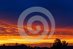 Beautiful sunset. Colorful dramatic sky at sunset. Layered rain clouds. Bright blue orange background. The texture of the sunset.