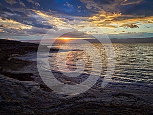 Beautiful sunset at Dead Sea, Jordan. Salt beach. Rays of lights