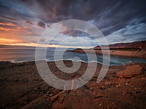 Beautiful sunset at Dead Sea, Jordan. Salt beach. Rays of lights