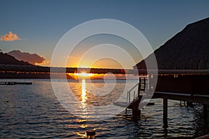 Beautiful sunset deflecting off rope from walk way of over the water bungalows