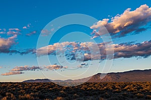 Beautiful sunset illuminates clouds over the Sangre de Cristo Mountains near Taos, New Mexico photo