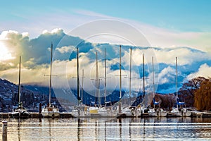 Beautiful sunset landscape featuring a fleet of sailboats in the distant horizon set stunning sunset