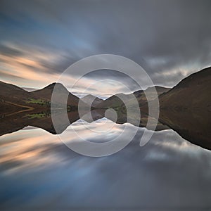 Beautiful sunset landscape image of Wast Water and mountains in photo