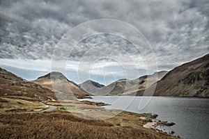 Beautiful sunset landscape image of Wast Water and mountains in photo