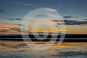 Beautiful sunset landscape over a Finnish lake. The space is flooded with gold