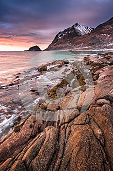 Sunset Norway landscape of picturesque stones on the arctic beach of cold Norwegian Sea