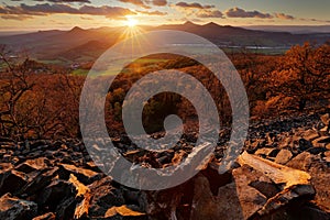 Beautiful sunset landscape with sun star. View from Plesivec hill, Ceske Stredohori, Czech. Evening villages. Sun with ping and or