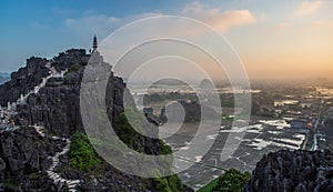 Beautiful sunset landscape viewpoint with white stupa from the top of Mua Cave mountain, Ninh Binh, Tam Coc, Vietnam.