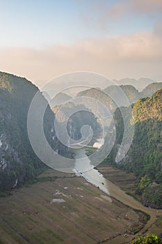 Beautiful sunset landscape viewpoint with white stupa from the top of Mua Cave mountain, Ninh Binh, Tam Coc, Vietnam.