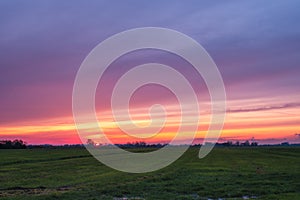 Beautiful sunset with a multi coloured sky over a Dutch agricultural polder landscape