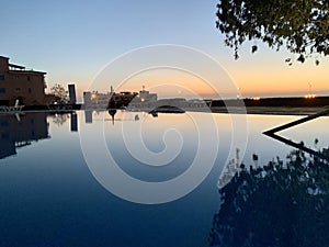 Beautiful sunset near apartment. tree reflection in swimming pool