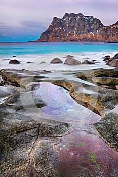 Beautiful sunset Norway landscape of picturesque stones on the arctic beach of cold Norwegian Sea